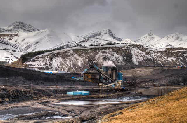 Mine de charbon entourée de montagnes aux sommets enneigés
