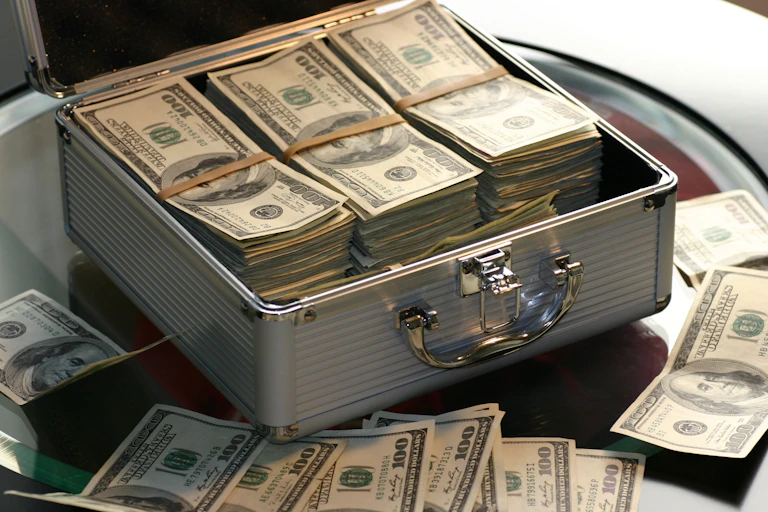 A metallic briefcase fille with American cash.