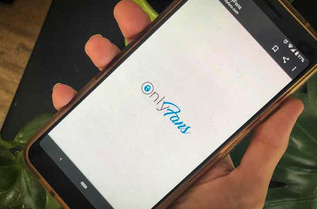 The screen of  a smart phone says 'OnlyFans'