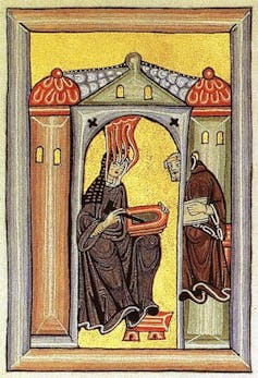An illumination shows Hildegard von Bingen experiencing a spiritual vision while dictating to a scribe.