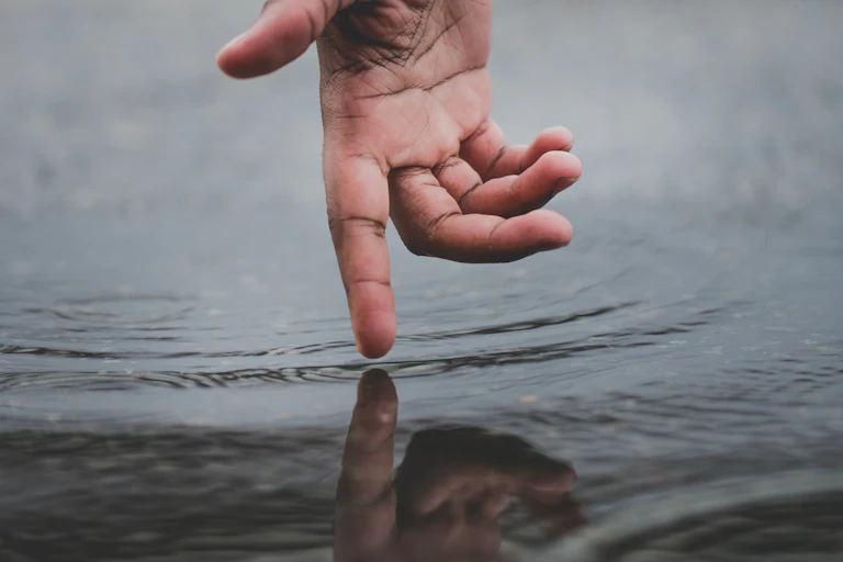 Hand dipping a finger into water
