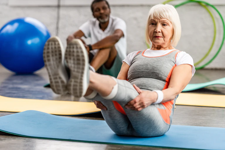 Middle-aged woman performing an ab exercise in the gym.