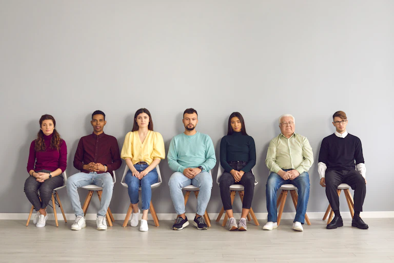Un groupe d'hommes et de femmes assis, attendant à l'hôpital.