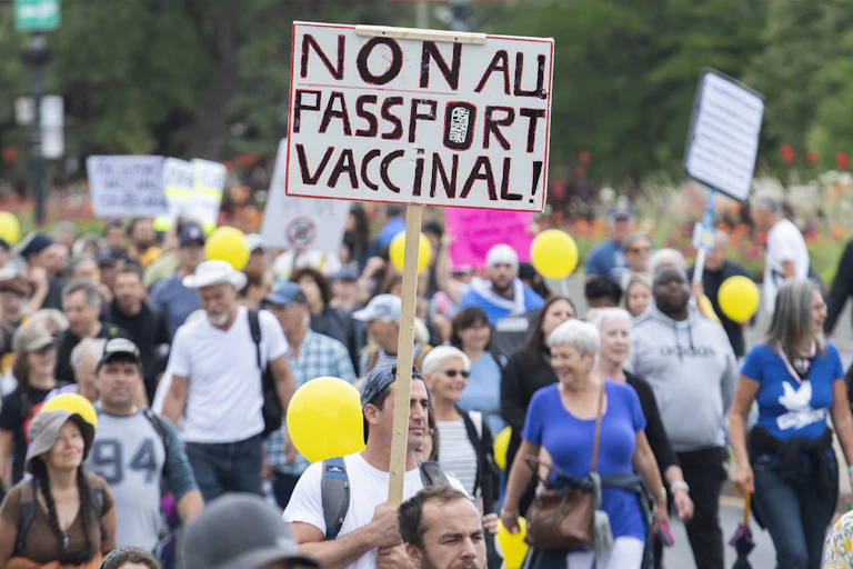 A crowd of protesters with a sign NON AU PASSPORT VACCINAL!