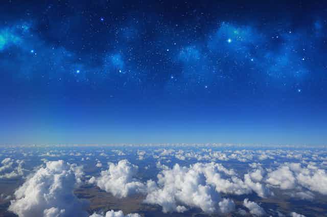 photograph of the atmosphere above clouds, with stars in the distance