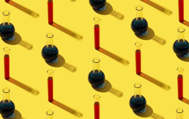 Test tubes and vials on a yellow background.