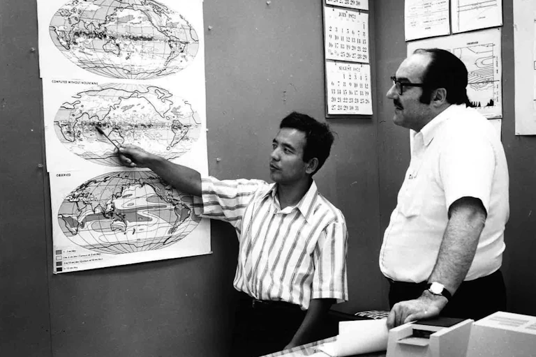 Two men look at maps