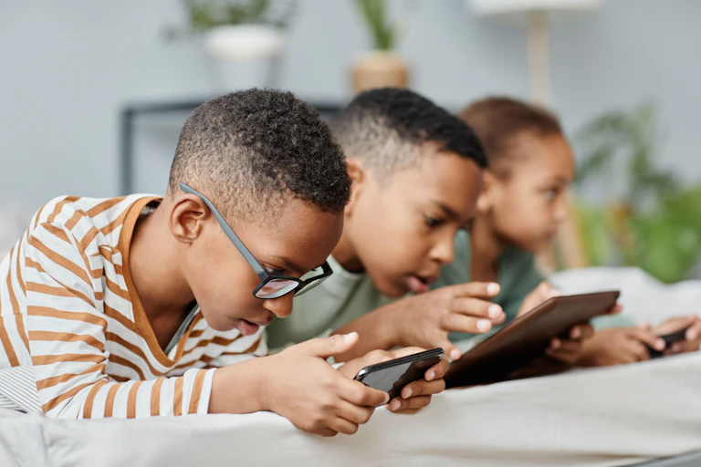 Three children on electronic devices