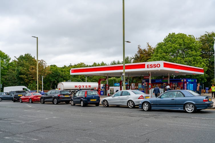 Cars queuing at a UK petrol station.