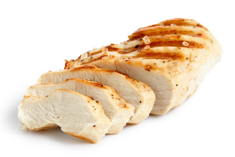 A partially sliced grilled chicken breast.