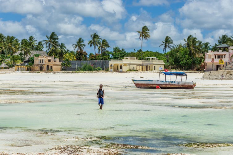 A child is running on the beach during low tide