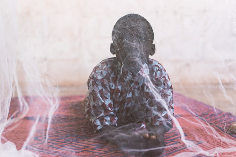 African child under mosquito net