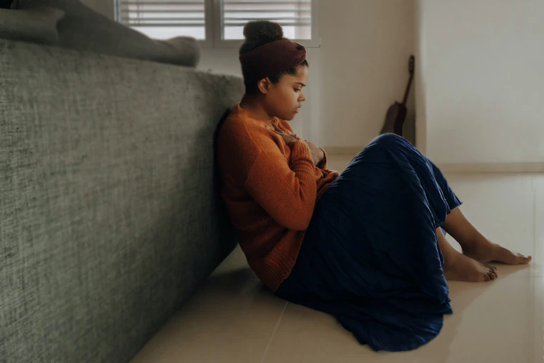 Anxious woman sitting against the back of a couch