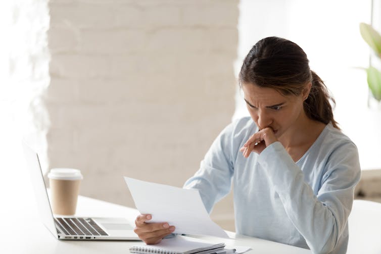 A woman looks at a legal letter