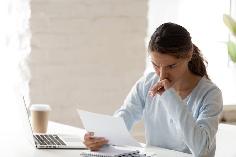 A woman looks at a legal letter