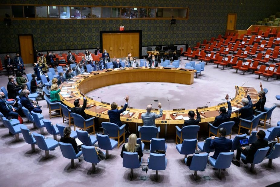 Representatives of the UN Security Council members raise their hands to vote