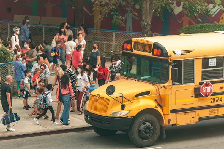 School children line up to get on a yellow schoolbus in New York City