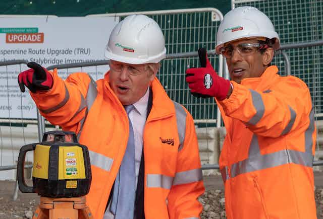 Boris Johnson and Rishi Sunak survey a railway site in Manchester,