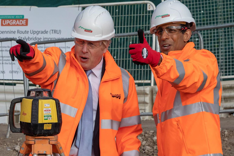 Boris Johnson and Rishi Sunak survey a railway site in Manchester,