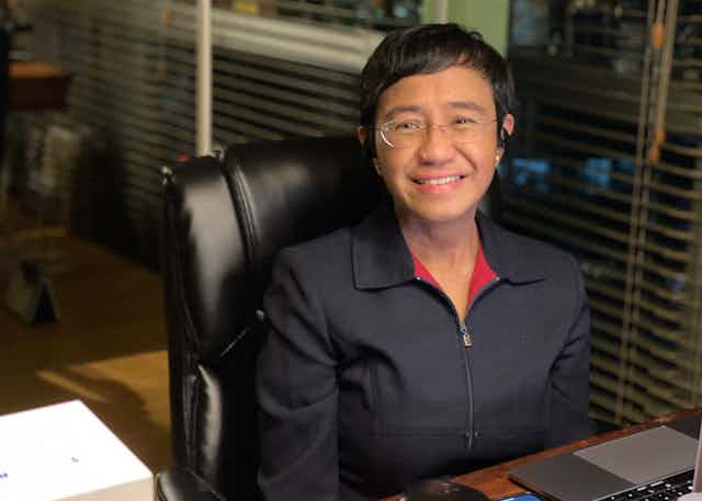Maria Ressa sat at a desk, smiling