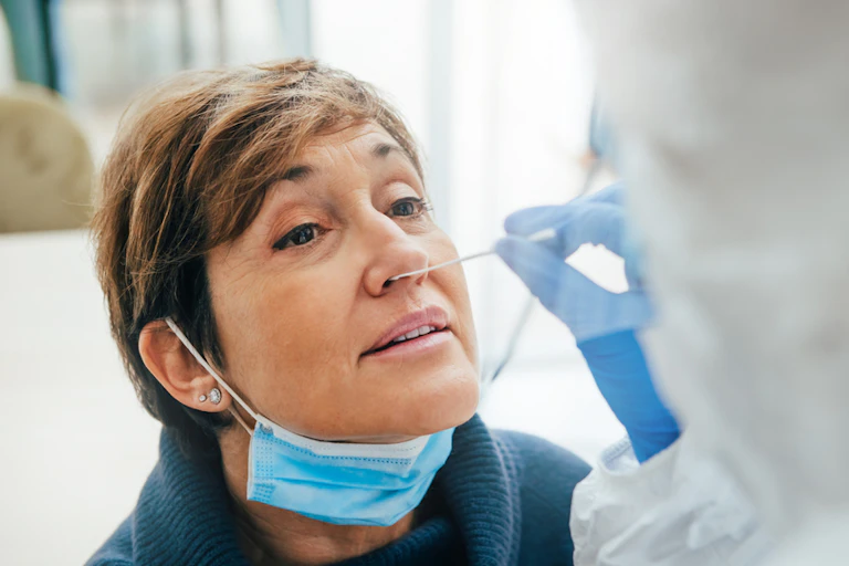 A woman having her nose swabbed for a PCR test