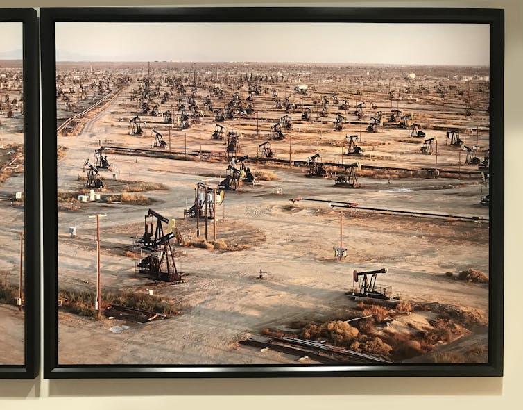 A photograph of tall towers on oil fields.