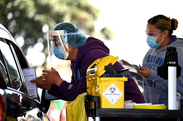 Vaccination team providing COVId-19 vaccinesin a drive-through clinic.