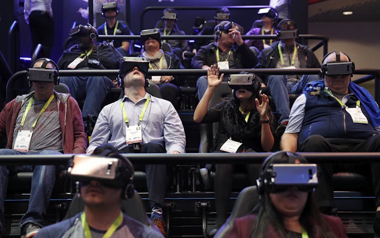 An audience wearing virtual reality headsets.