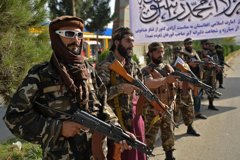 Taliban fighters stand guard near the venue of an open-air rally in a field on the outskirts of Kabul on October 3, 2021