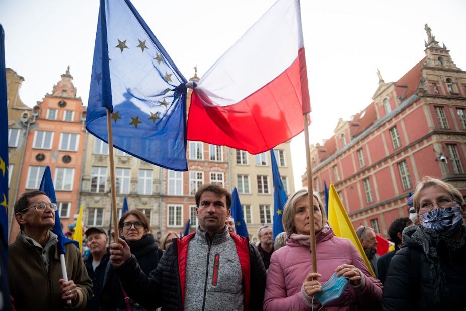 Drapeaux polonais et européens noués ensemble pendant une manifestation en ville.