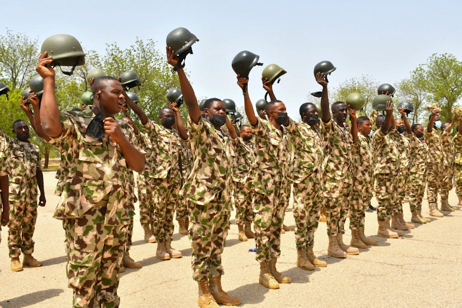 A group of soldiers raising their helmets.