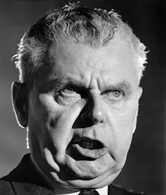 A black-and-white photo of a man talking.