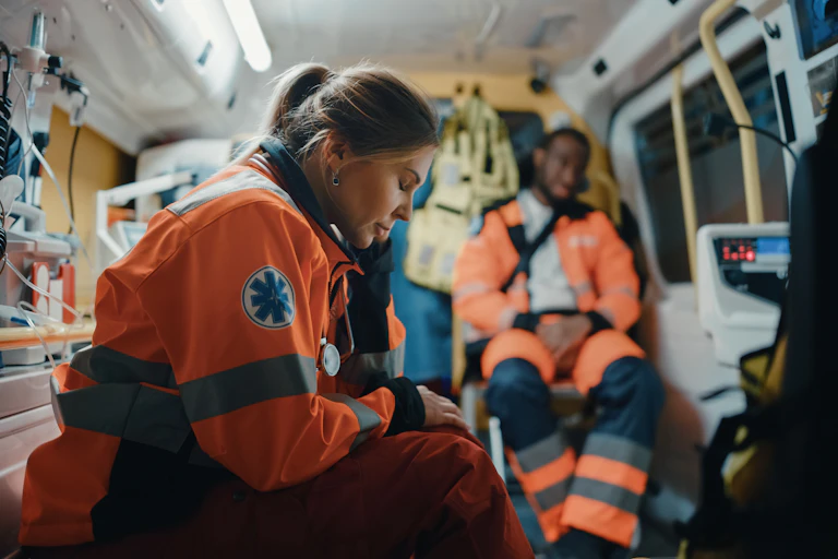 Two paramedics looking tired in an ambulance