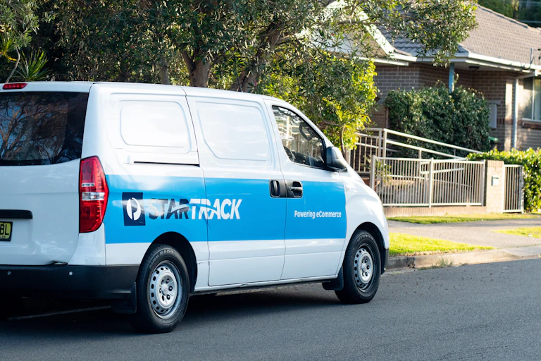 A delivery van waits in a street
