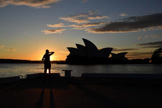 Person standing in front of the Sydney Opera House