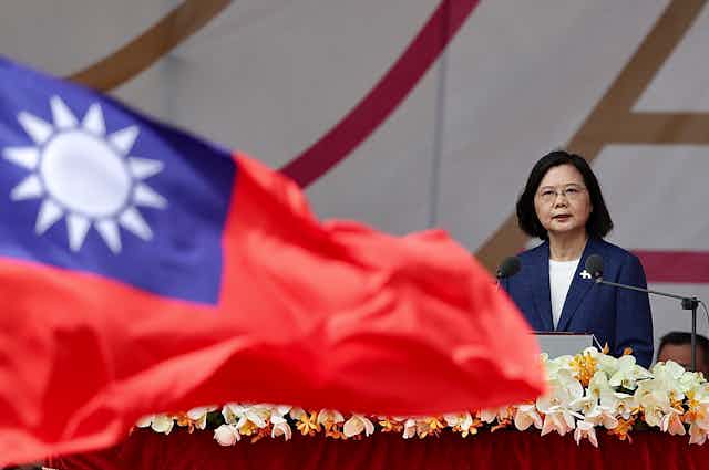 Taiwanese president, Tsai Ing-wen, delivers a speech with a Taiwanese national flag waving in the foreground.ei, Taiwan, 10 October 2021.
