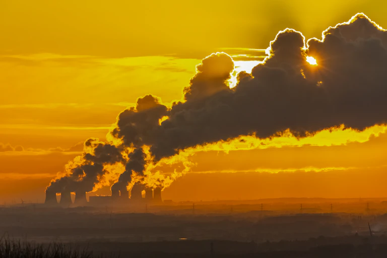 Steam from power station with sunset behind.