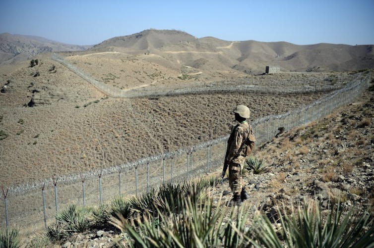 Un soldat pakistanais à côté d’une nouvelle clôture le long de la frontière afghane, au poste de Kitton Orchard, dans la province tribale pakistanaise du Nord-Waziristan