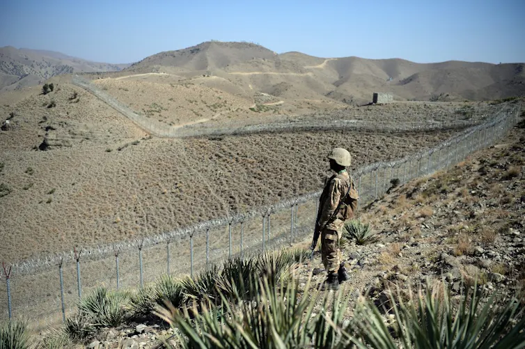 Un soldat pakistanais à côté d’une nouvelle clôture le long de la frontière afghane, au poste de Kitton Orchard, dans la province tribale pakistanaise du Nord-Waziristan