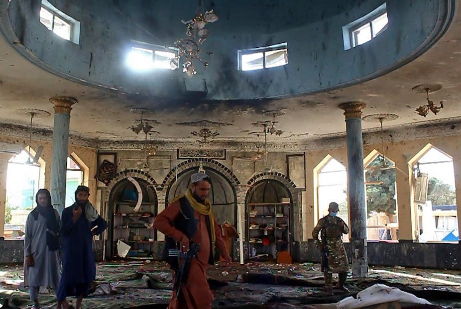 Taliban fighters investigate inside a Shiite mosque after a suicide bomb attack in Kunduz on October 8, 2021. 
