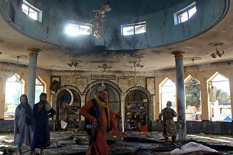 Taliban fighters investigate inside a Shiite mosque after a suicide bomb attack in Kunduz on October 8, 2021.