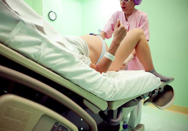 obstetrician attends a reclined woman in labor