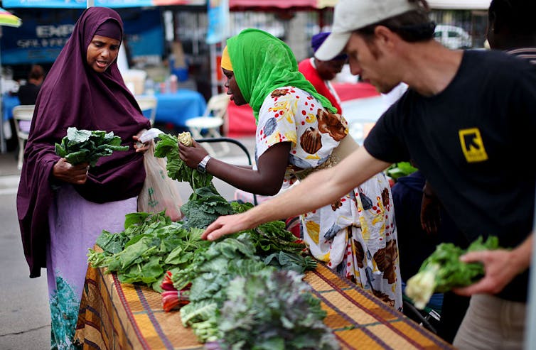 Woman holds vegetables.