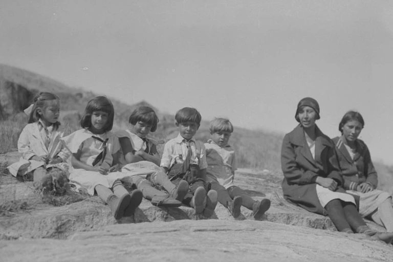 children sitting outside on a rock