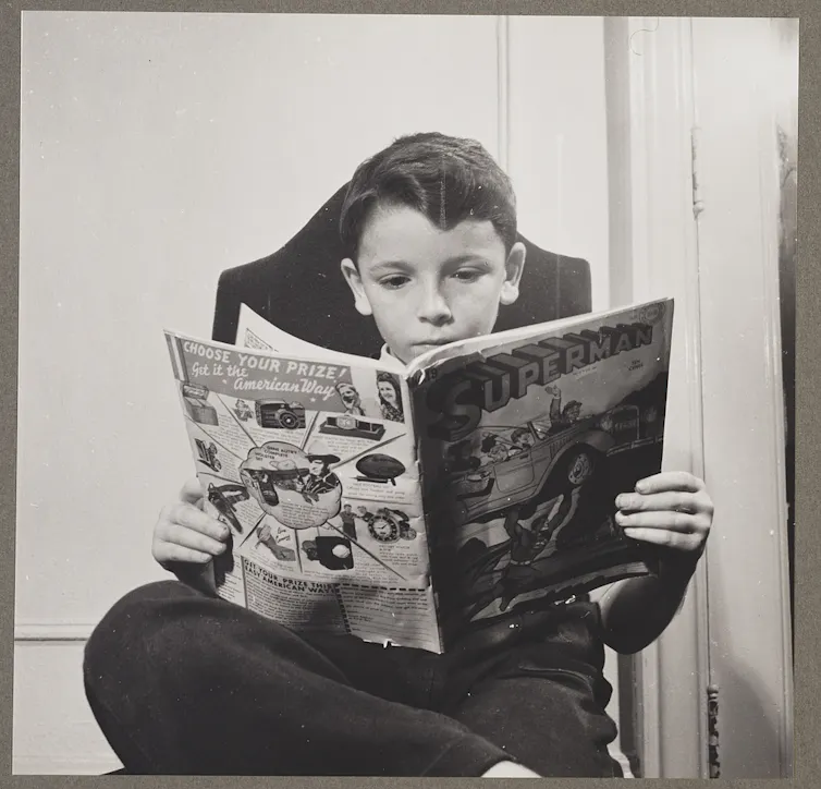 Vintage photo of a boy reading Superman