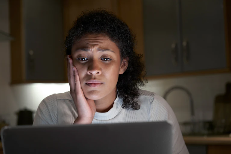 Woman at her laptop looking concerned