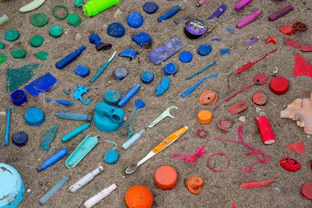 Coloured pieces of plastic laid out on sand