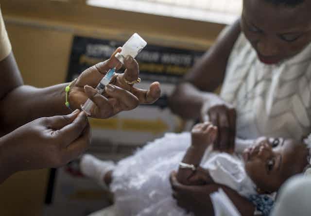 Un dose de vaccin est préparée pour être injectée à un enfant dans un clinique au Ghana.