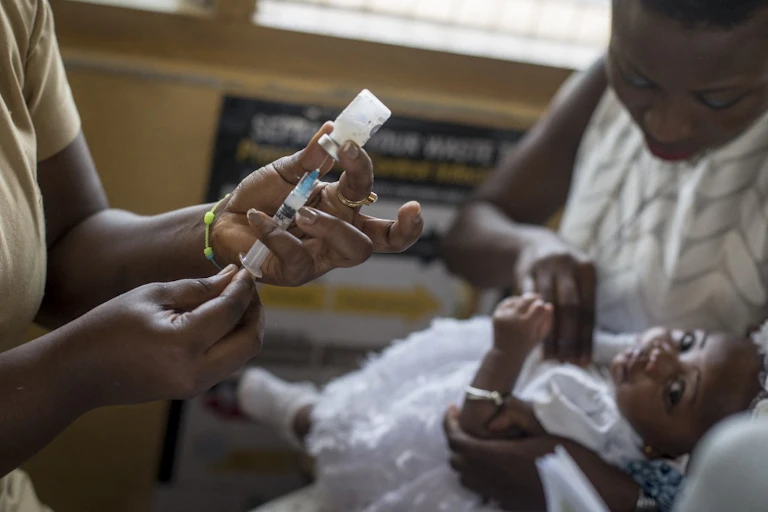 Un dose de vaccin est préparée pour être injectée à un enfant dans un clinique au Ghana.