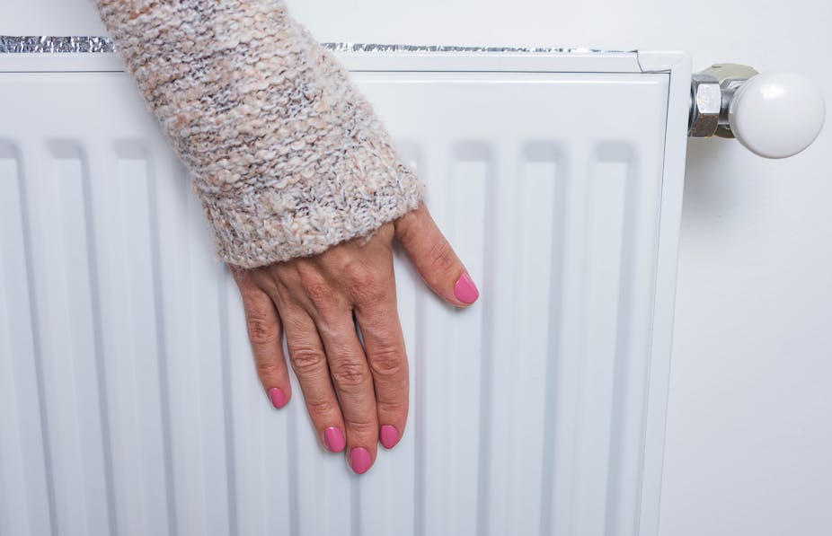 Woman touching radiator. 